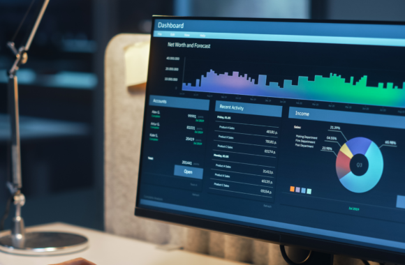 Mann arbeitet an einem PC mit einem Finanz-Dashboard, das Diagramme, Kontodaten und aktuelle Aktivitäten anzeigt.