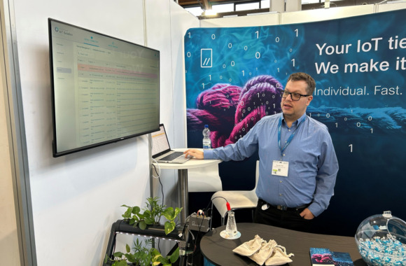 Mann auf einer Messe zeigt einen IoT-Showcase