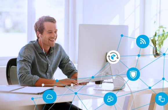 Mann arbeitet lächelnd am Computer mit dem doubleSlash Update Manager, während vernetzte Symbole für Cloud, Sicherheit und Datenübertragung den digitalen Arbeitsplatz darstellen – Symbolbild für Cyber Resilience und moderne IT-Infrastruktur.